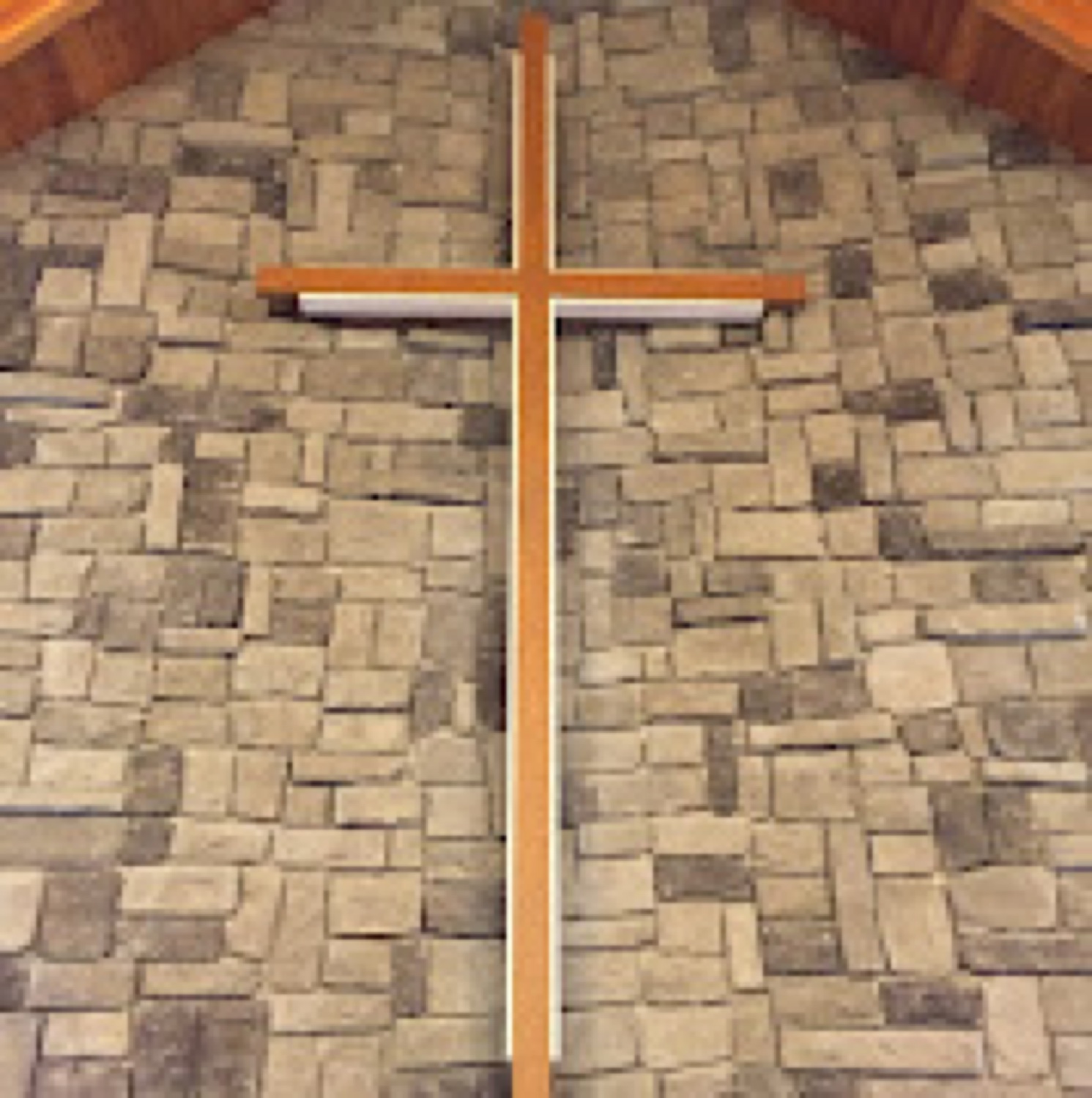 The wooden cross on the stone wall behind the altar